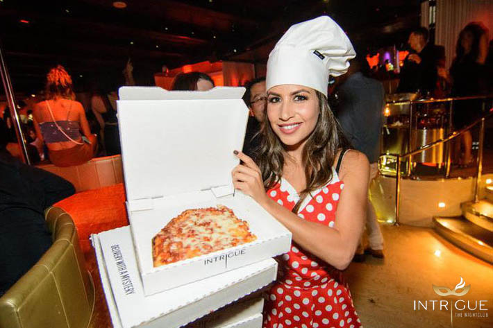 A waitress holding pizza boxes at Intrigue