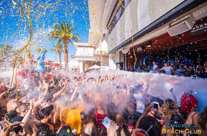 A photo of the pool party at Encore Beach Club featuring streamers and smoke machines