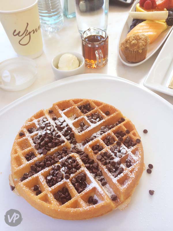 Chocolate chip waffle with powdered sugar and syrup